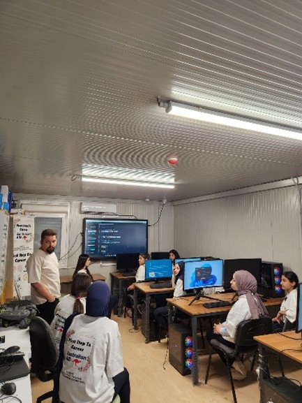 A group of people in a room with computersAI-generated content may be incorrect.