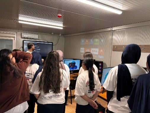 A group of people in a room with computersAI-generated content may be incorrect.