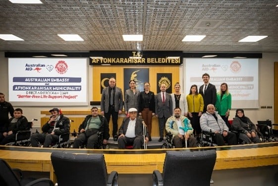 A group of people standing in a roomAI-generated content may be incorrect.